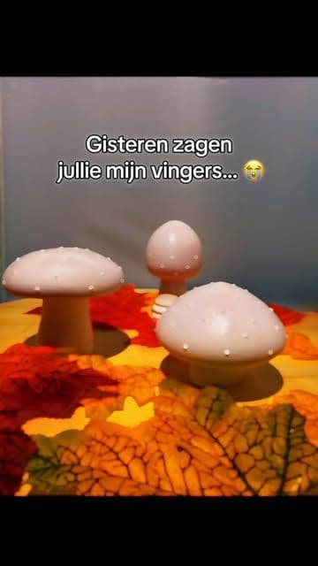 Drie handgemaakte paddenstoelen van keramisch gips op herfstbladeren